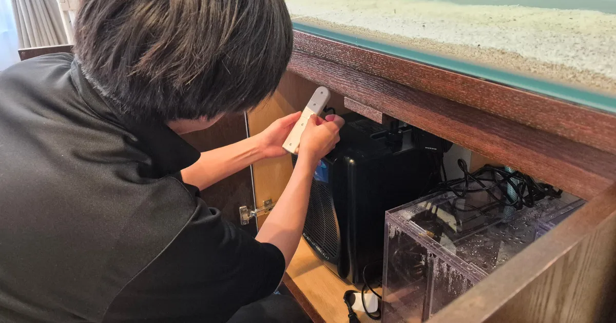 水がかからない位置に電源タップを固定する様子